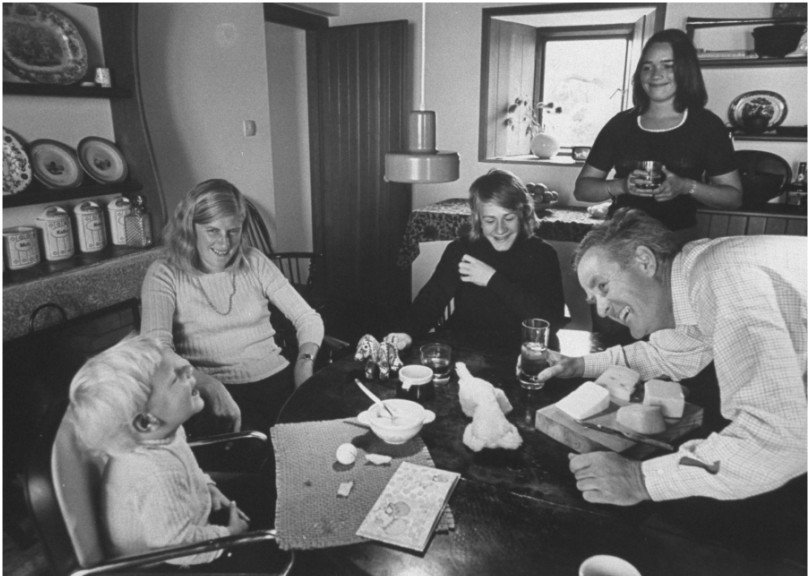 Black and white photograph of family laughing at kitchen table