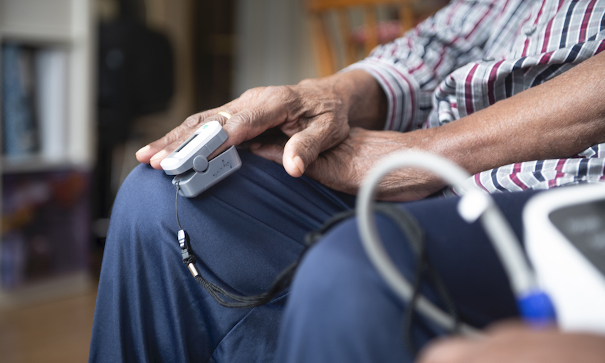 closeup of hands of elderly person with blood pressure monitor