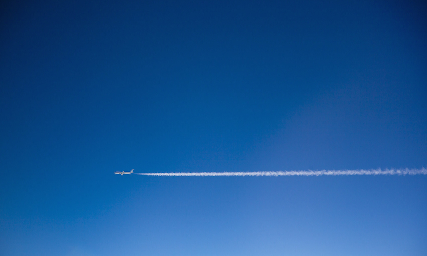 Blue sky, a plane leaving white vapour trails