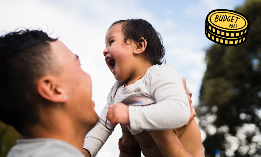 A happy Māori man lifts up his laughing baby.
