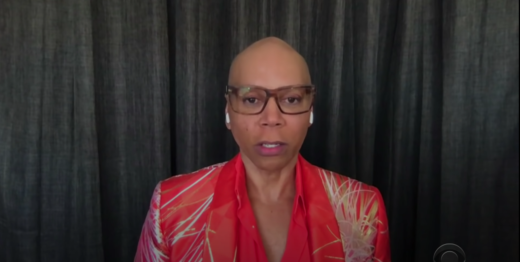 RuPaul in front of curtains