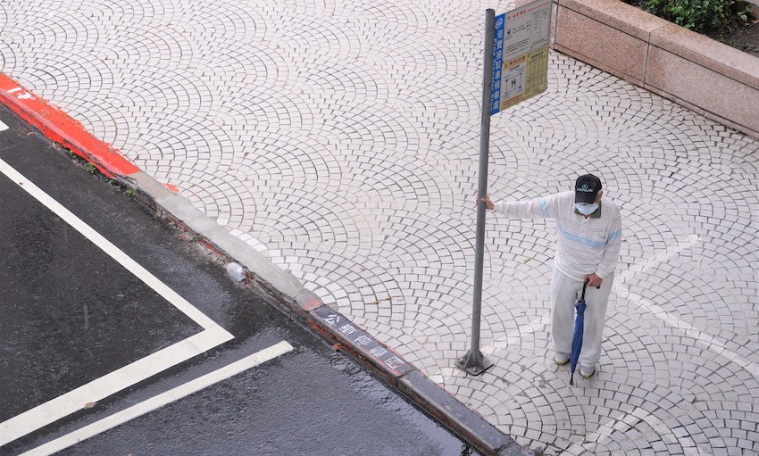 A masked man at a bus stop in Taipei